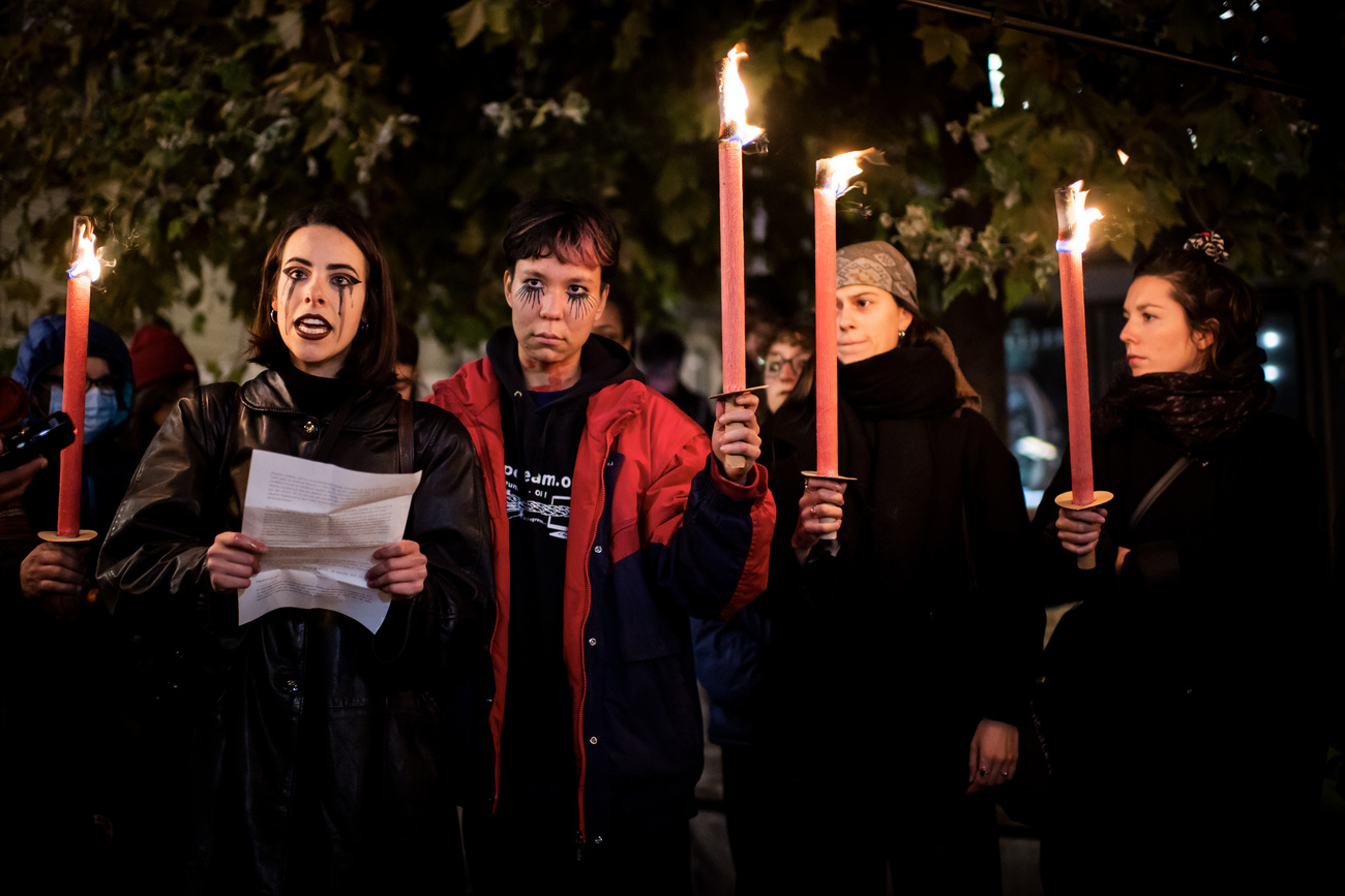 Grupo de mujeres con antorchas y lágrimas pintadas, en una manifestación