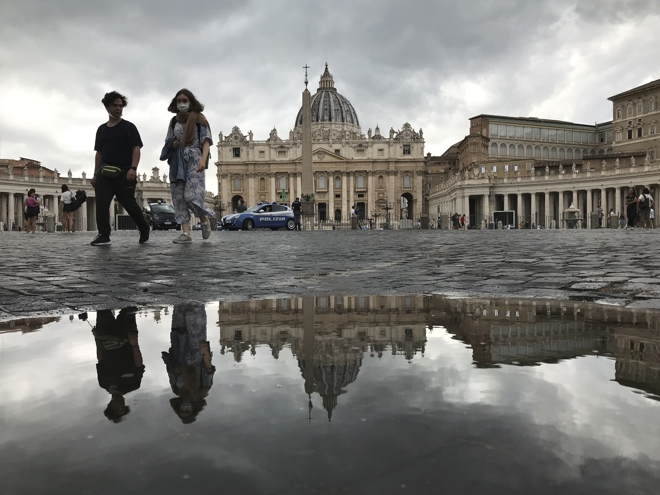 piazza san pietro fotografata a velo del suolo. due turisti passeggiano