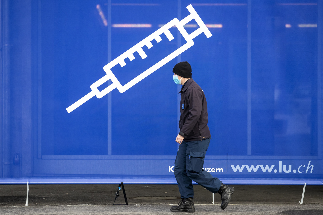 Hombre caminando junto a afiche de vacunación