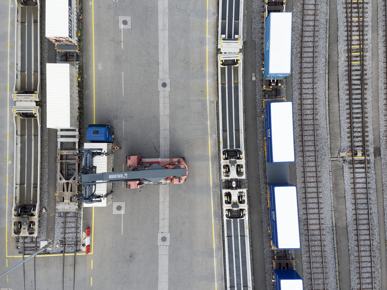 A mobile crane is used to unload containers from trucks onto freight trains at Dietikon, Switzerland, on June 21, 2019. 