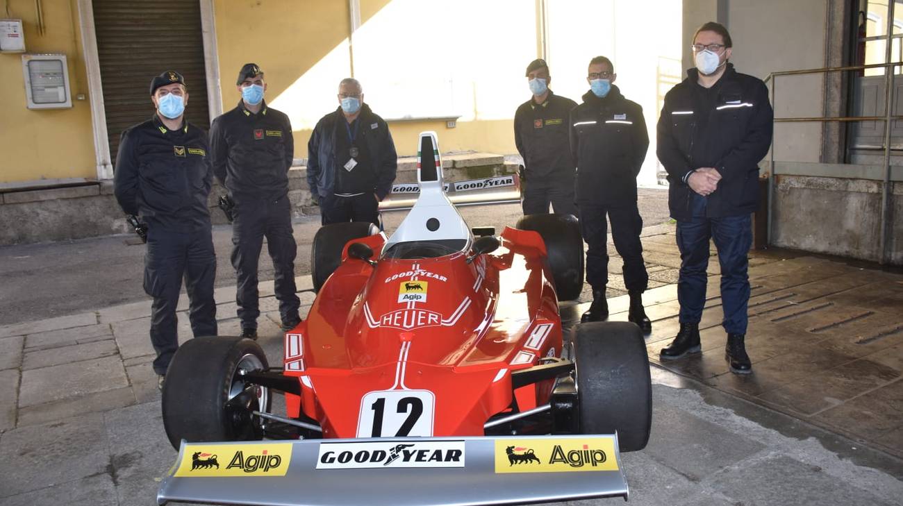 finanzieri a fianco di un auto di formula 1