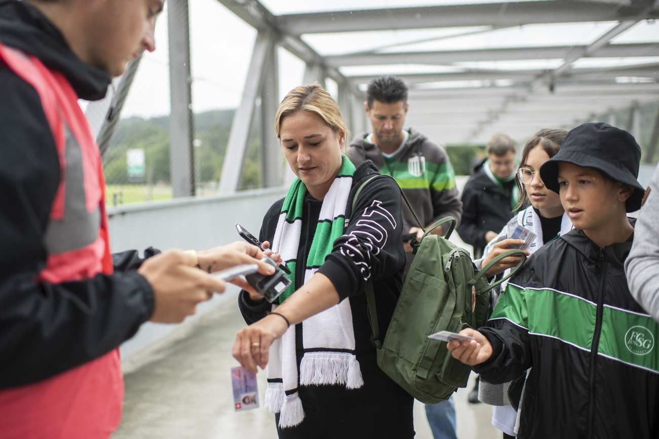 Official checking the Covid certificate of young football fans
