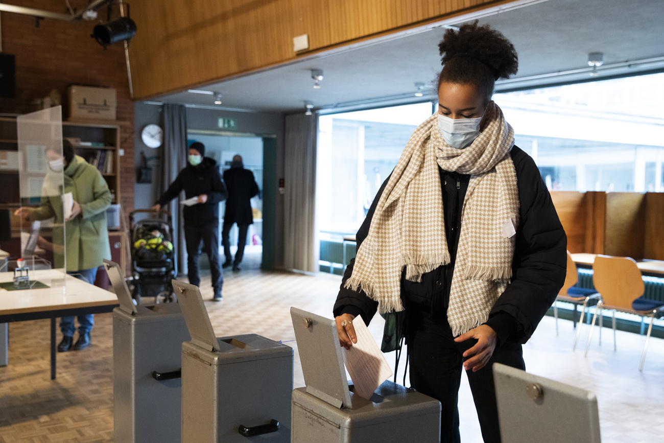 Una mujer deposita su boletín de voto.