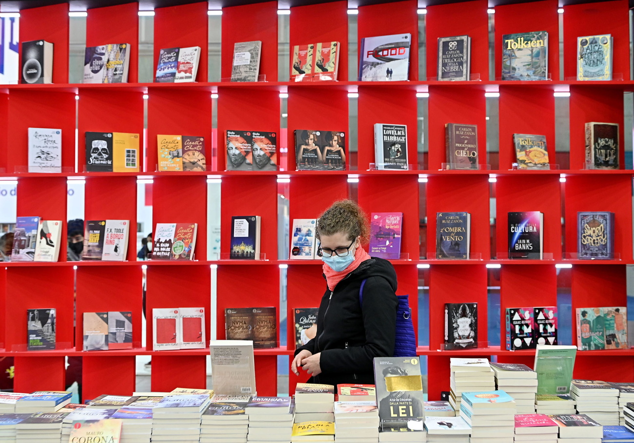 persona con mascherina osserva dei libri