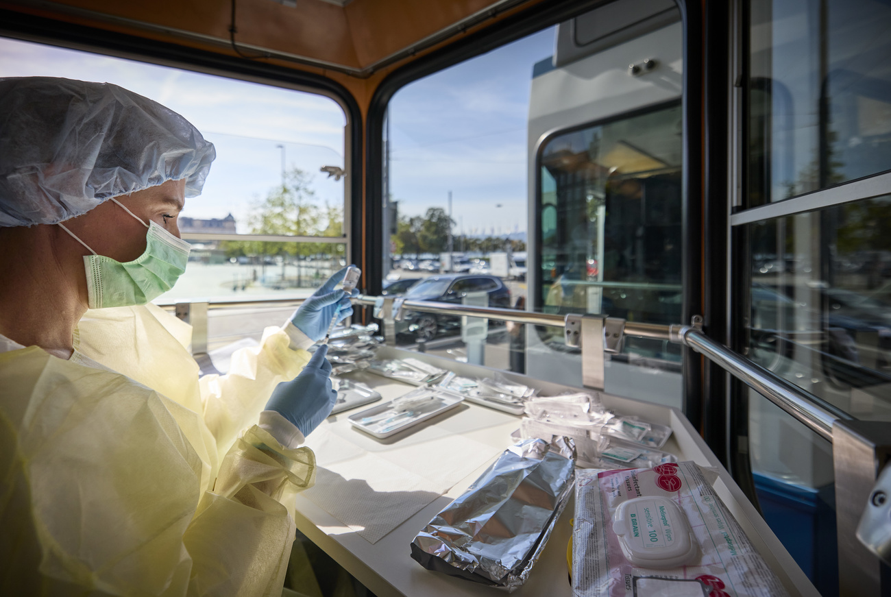 Un enfermero prepara vacunas en un tranvía.