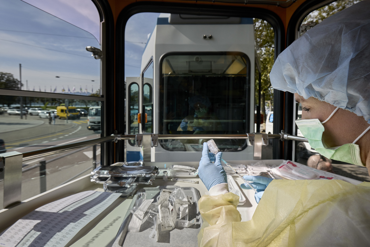 Nurse preparing an anti-Covid shot in a Zurich tram
