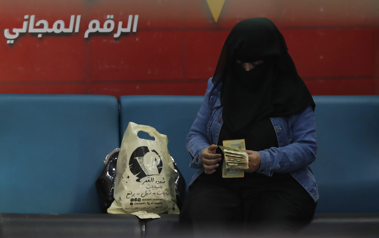 Yemeni woman counts banknotes.