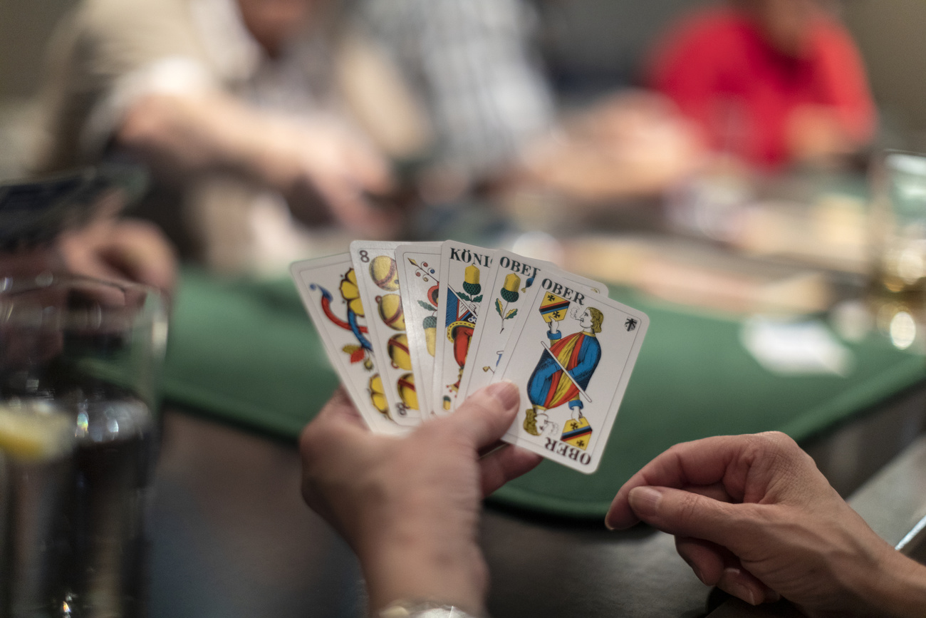 Person holding some Jass cards