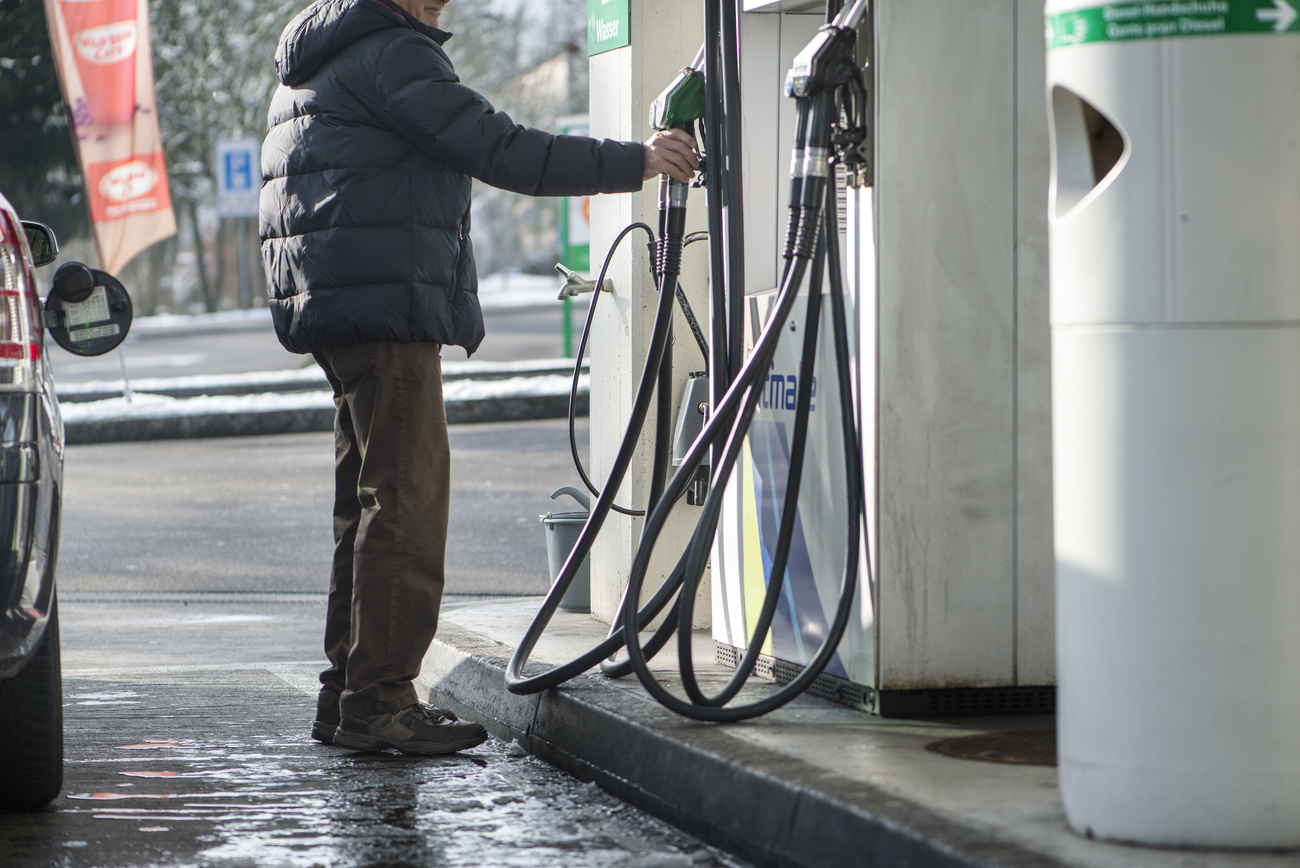 uomo con giacca invernale si accinge a fare il pieno