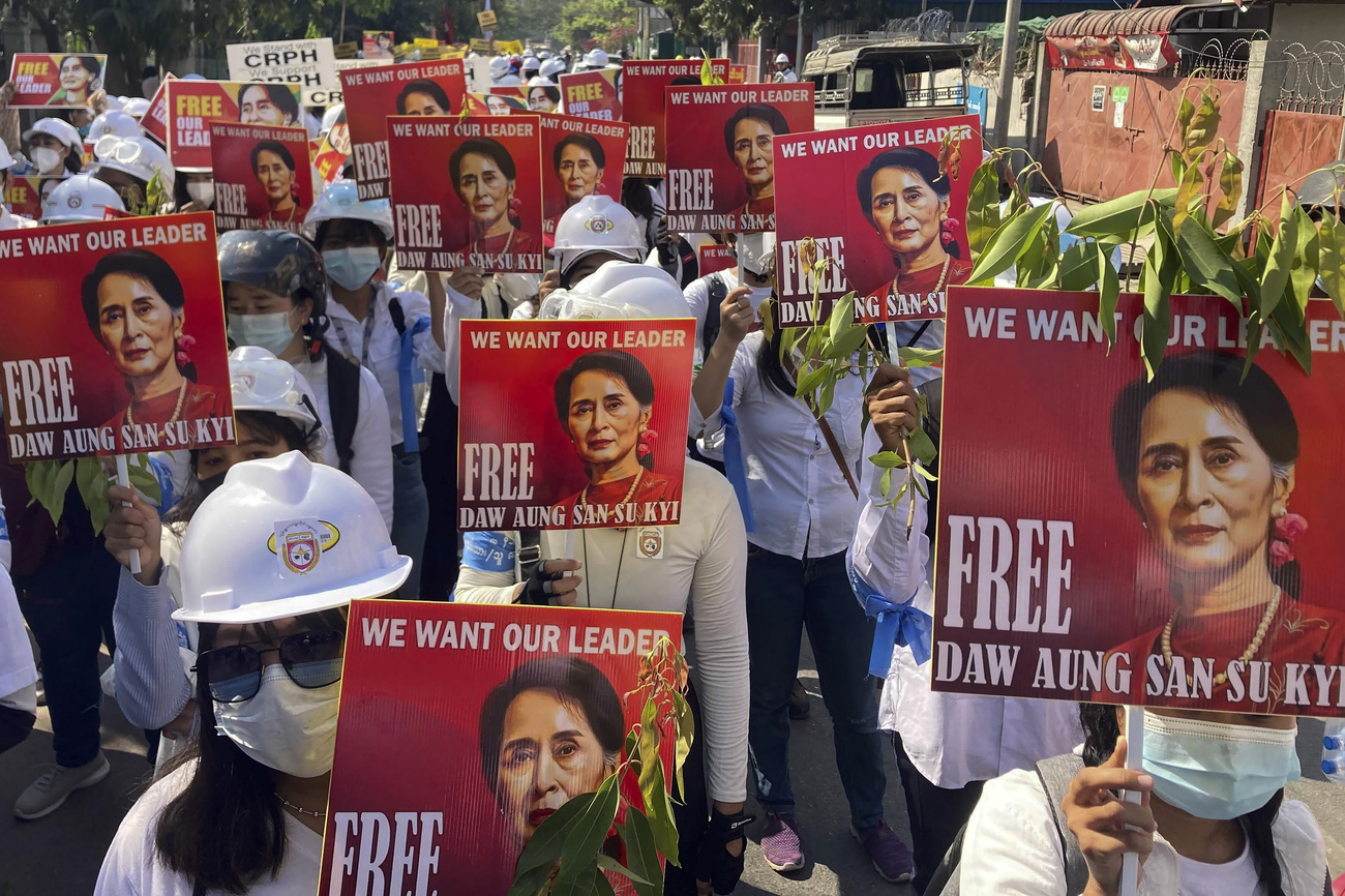 Demonstrators hold signs calling for the release of Aung San Suu Kyi during a protest in March.