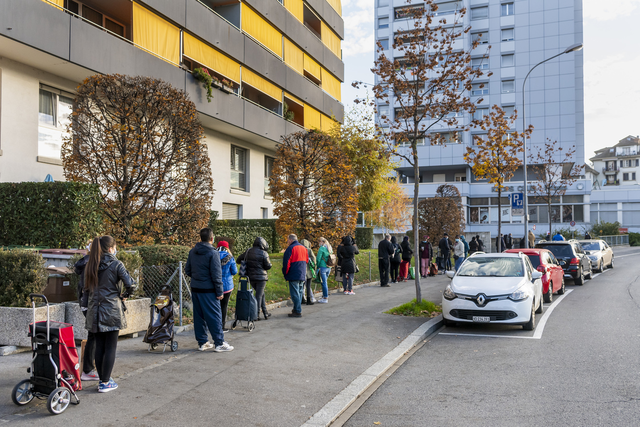 Bedürftige Menschen warten auf die Verteilung von Lebensmitteltüten