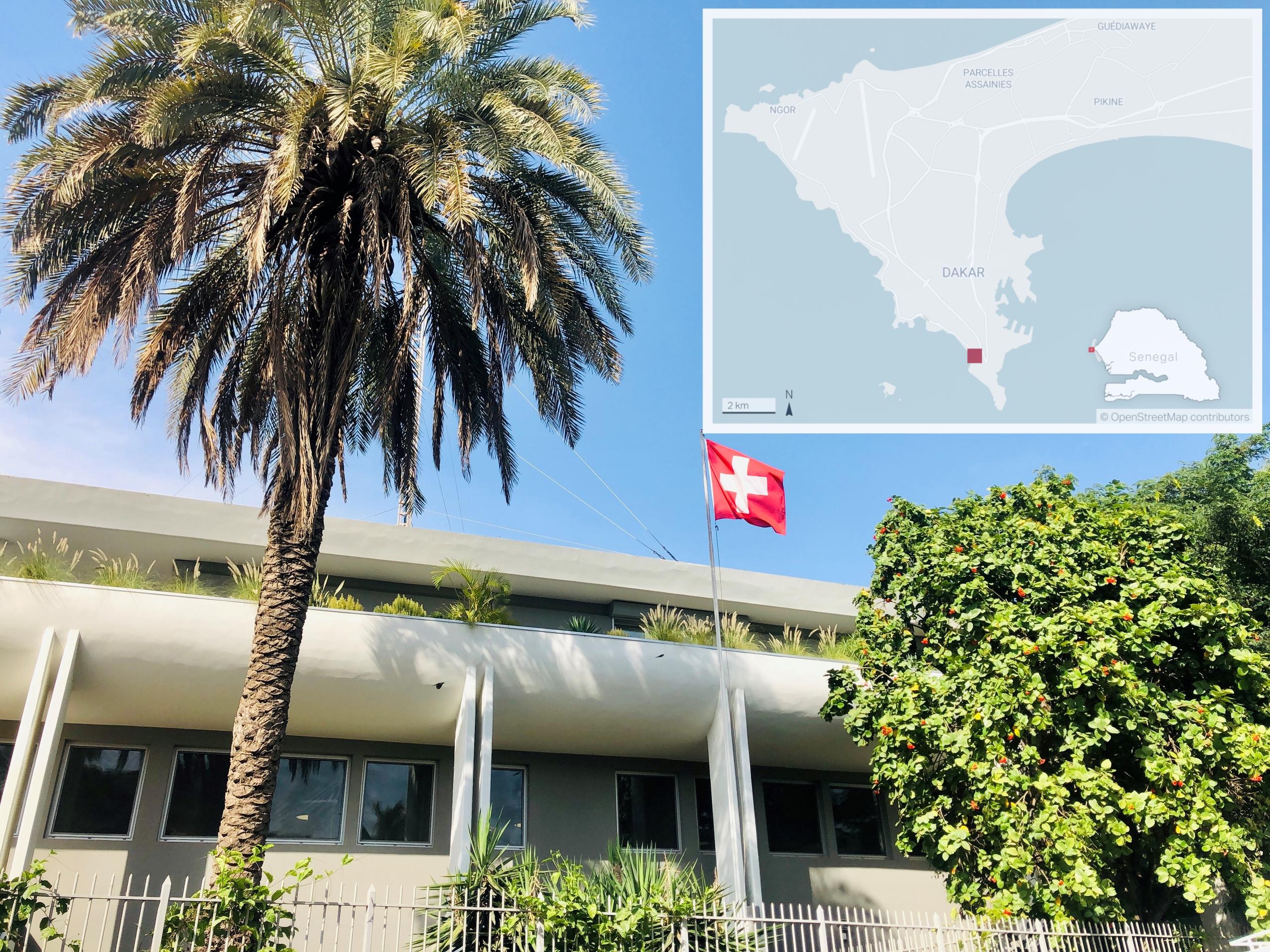 Vista esterna di edificio moderno con bandiera svizzera sul fronte e palma in giardino; a lato dell immagine, mappa del Senegal