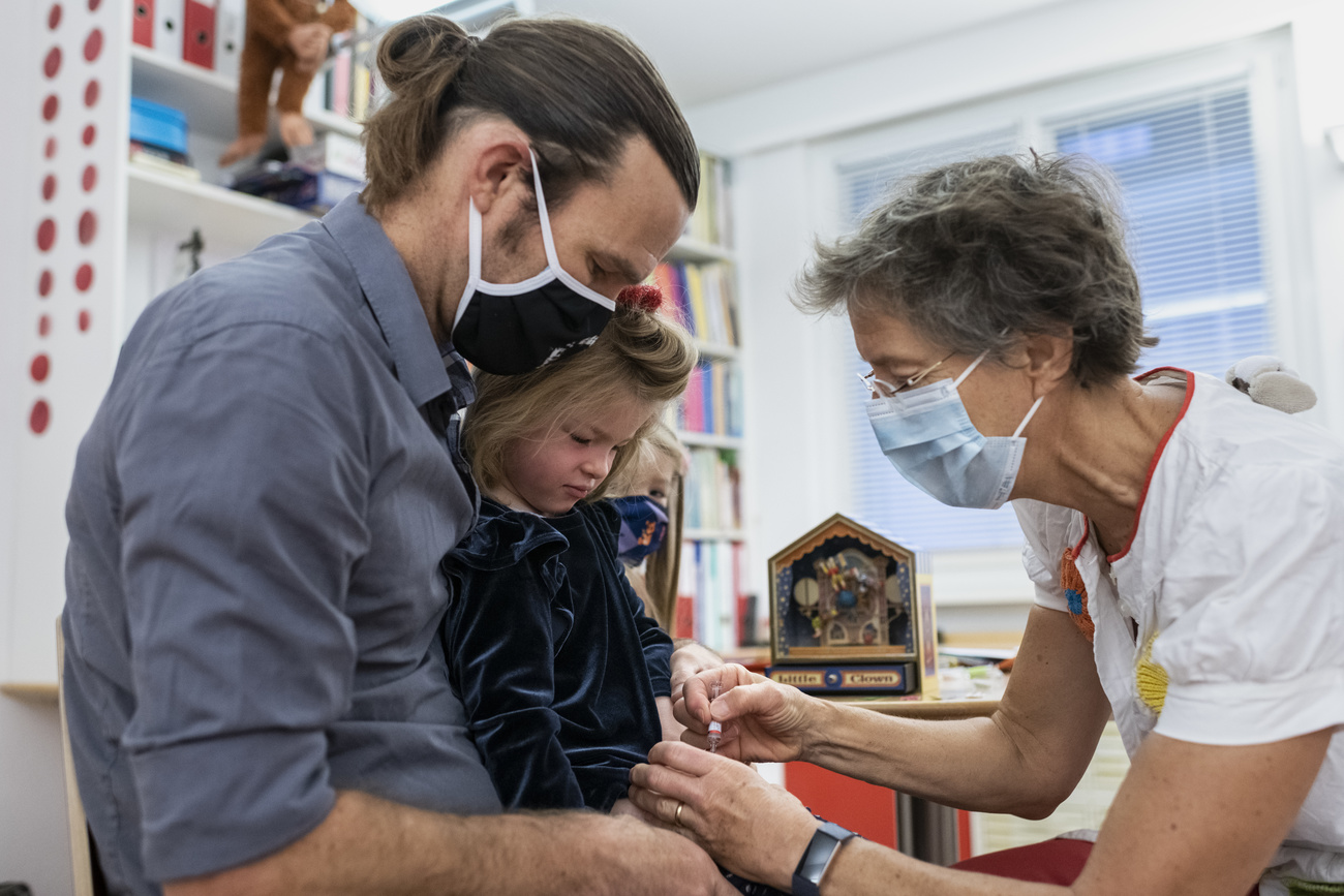 Un médico aplica una vacuna a una niña