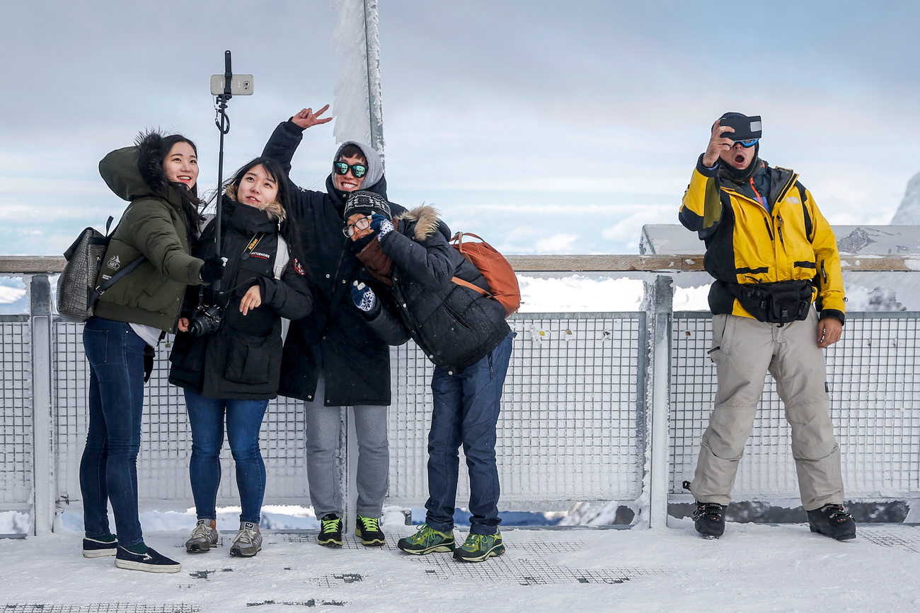 Asian tourists taking selfies in front of Eiger Glacier