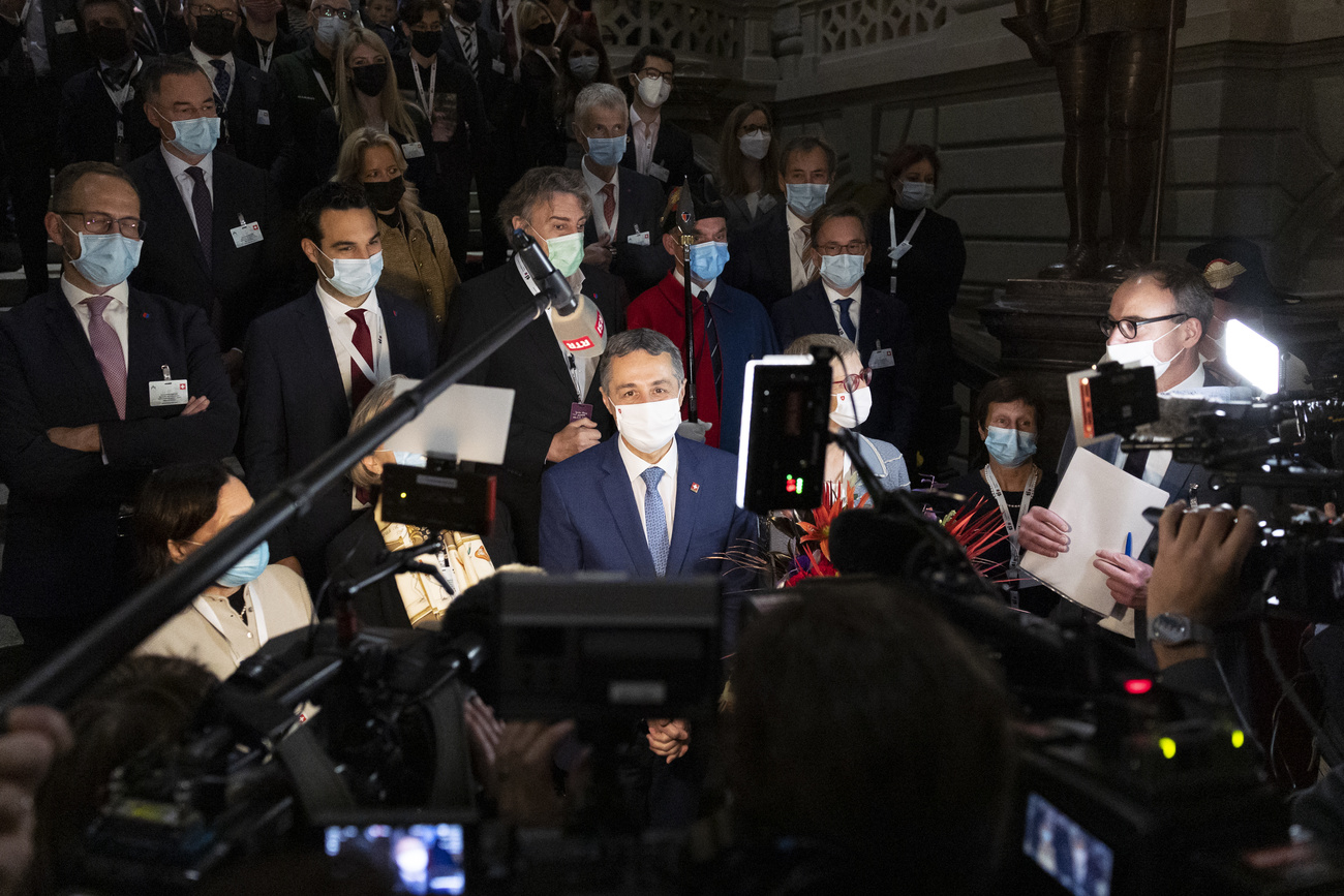 ignazio cassis attorniato da giornalisti