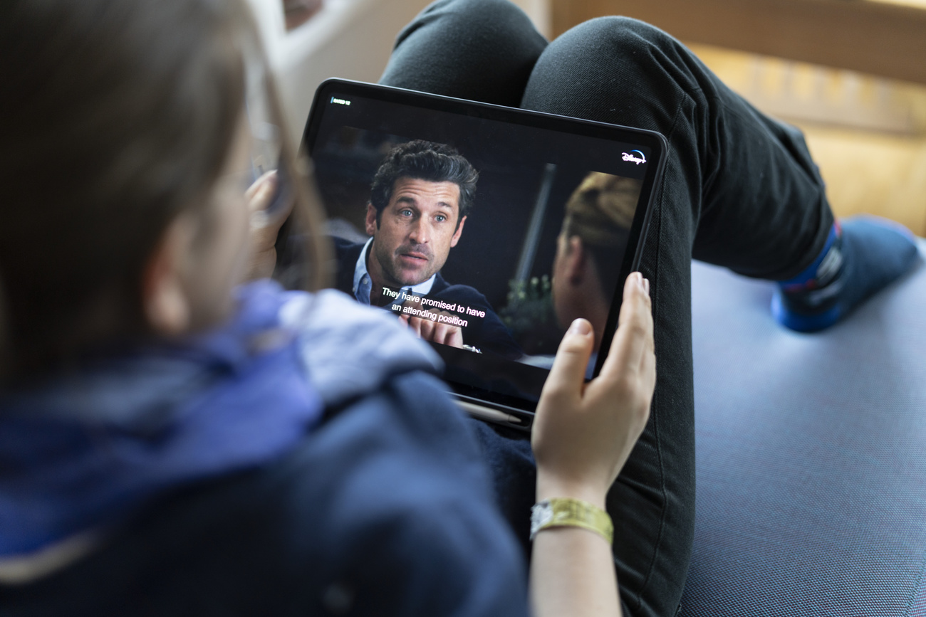 persona guarda film su ipad appoggiato alle ginocchia