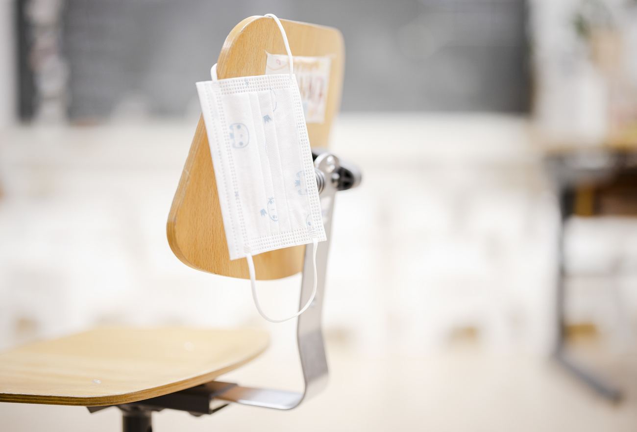 Empty chair with hygienic mask in classroom
