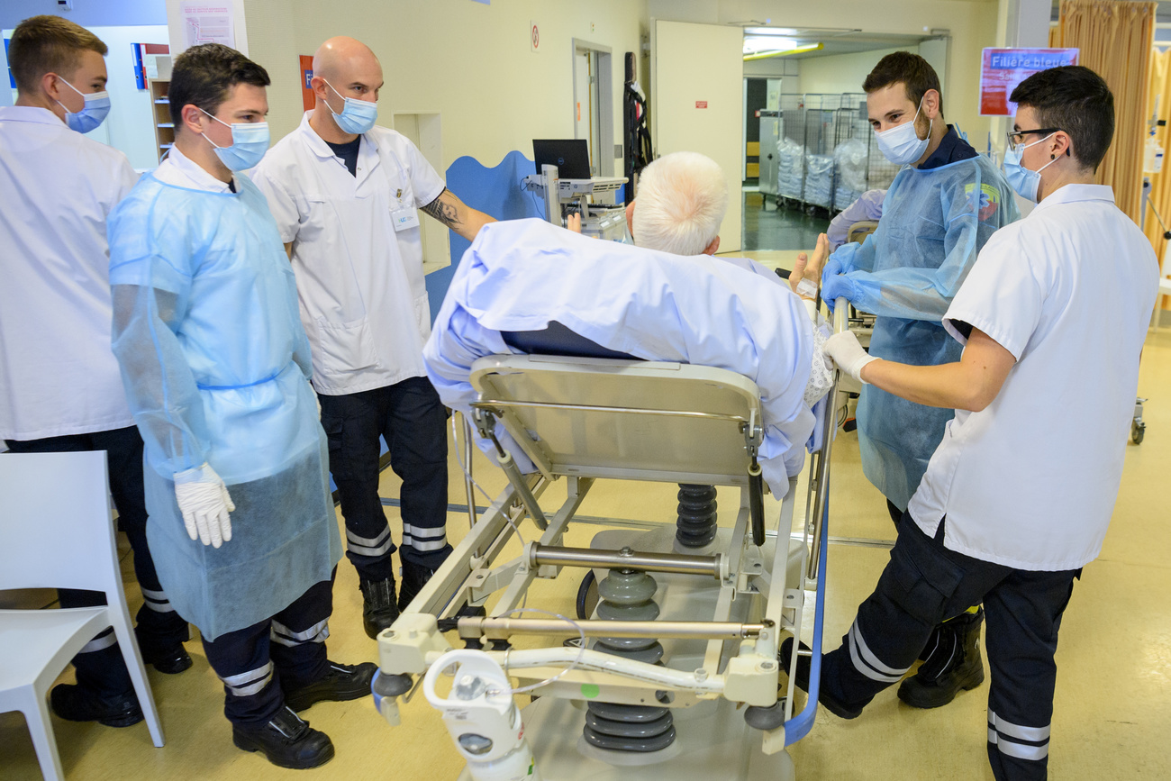 Doctors attend to an elderly patient in hospital