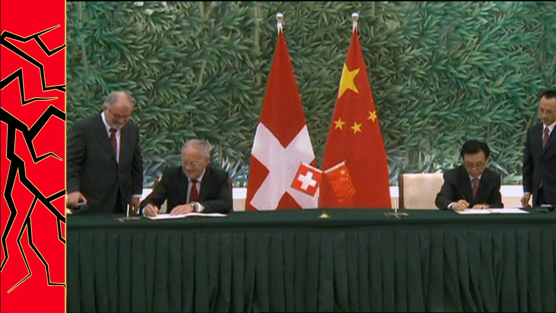 Un funzionario svizzero firma un documento con un funzionario cinese.