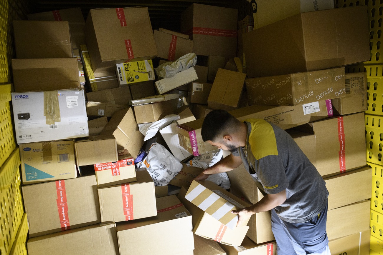 Postal worker with mountain of parcels