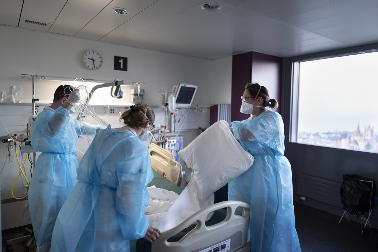 Care workers in a blue protective suits in a hospital room
