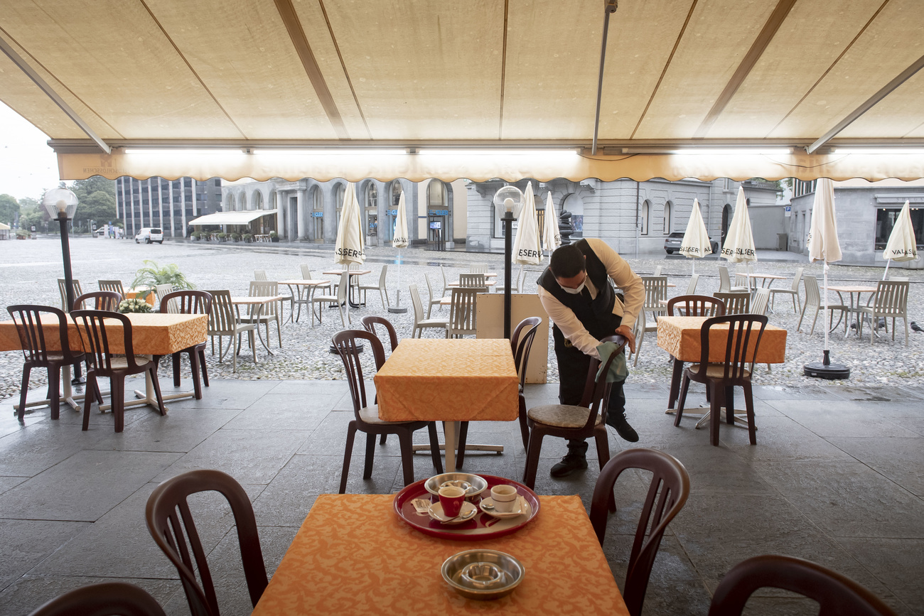 Waiter cleans a chair at an empty restaurant