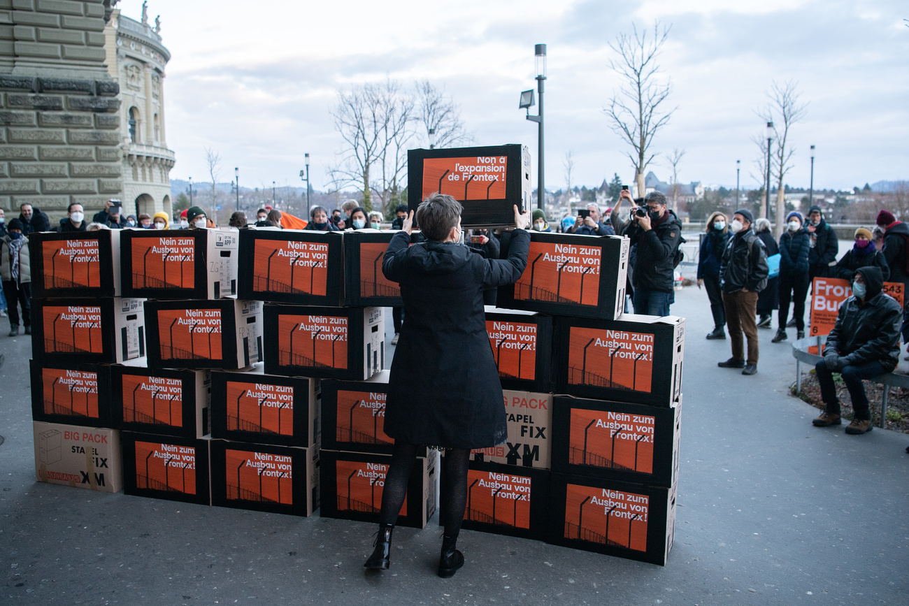 Campaigners with wall of cardboard boxes with signatures