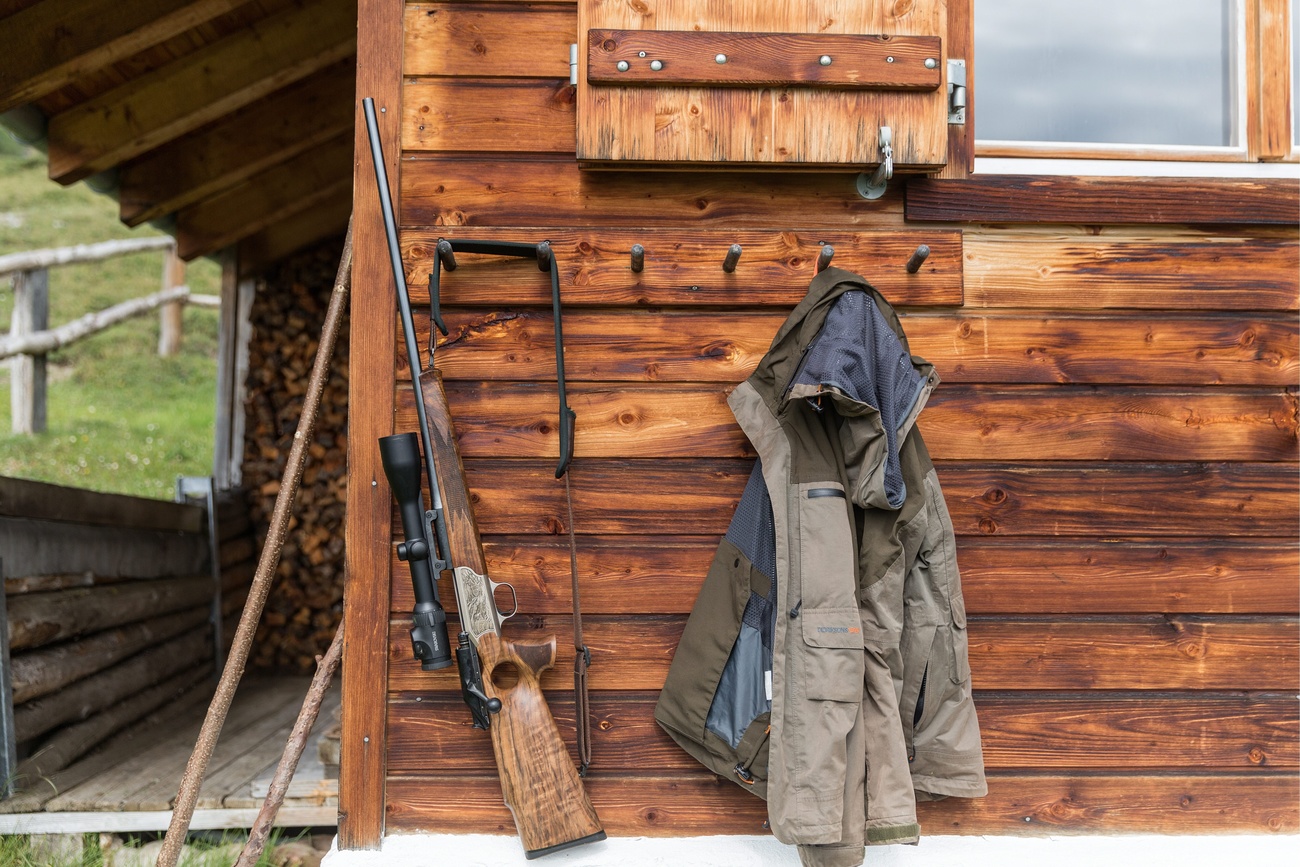Rifle leans against log cabin