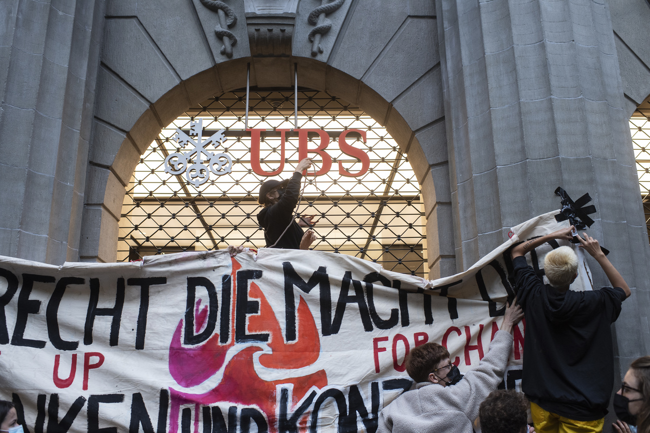 Climate protestors set up banners outside a UBS building