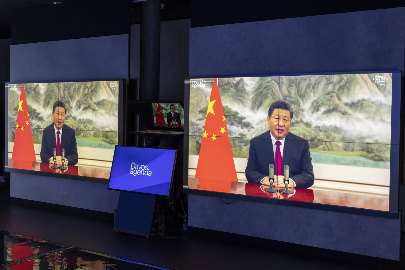 Screens show Chinese President Xi Jinping giving a speech.
