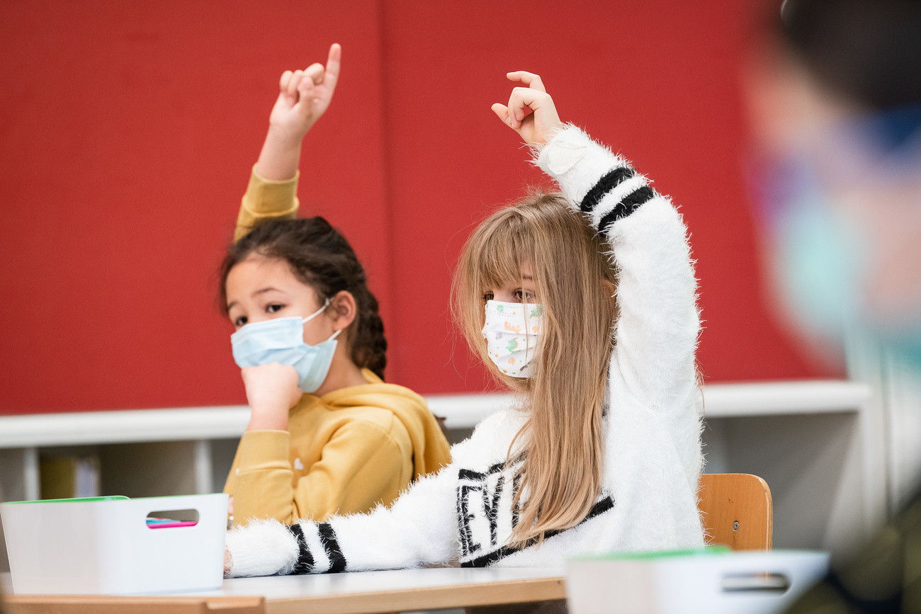 Due allieve della scuola elementare di Chiasso alzano la mano per intervenire.