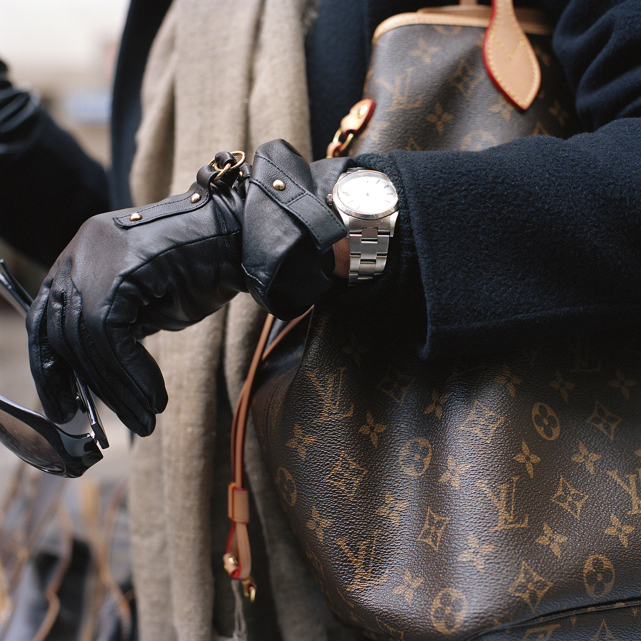 A woman with bag, gloves and glasses.