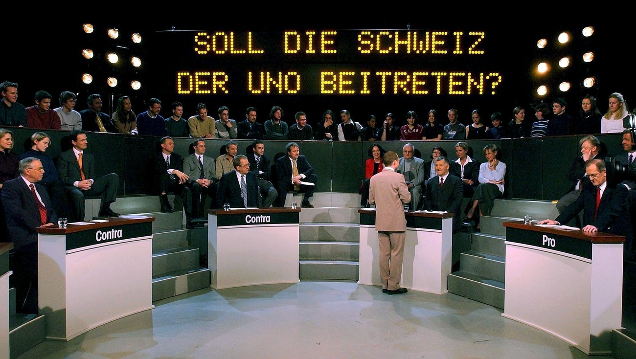 2002年2月14日，國民院議員克里斯托福·布勞赫(Christoph Blocher，最左)和聯邦委員約瑟夫·戴斯(Joseph Deiss，最右)在瑞士德語電視台演播室錄製UNO Arena專題節目。