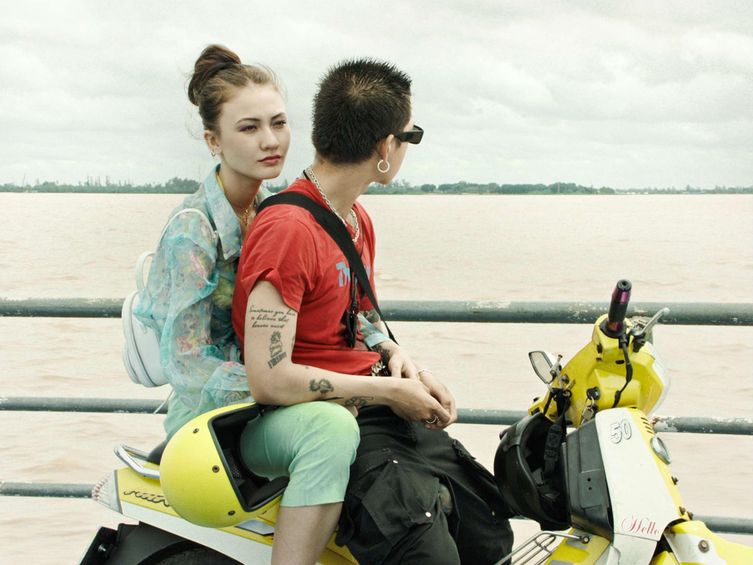 Escena de El río invisible :pareja en moto junto al río