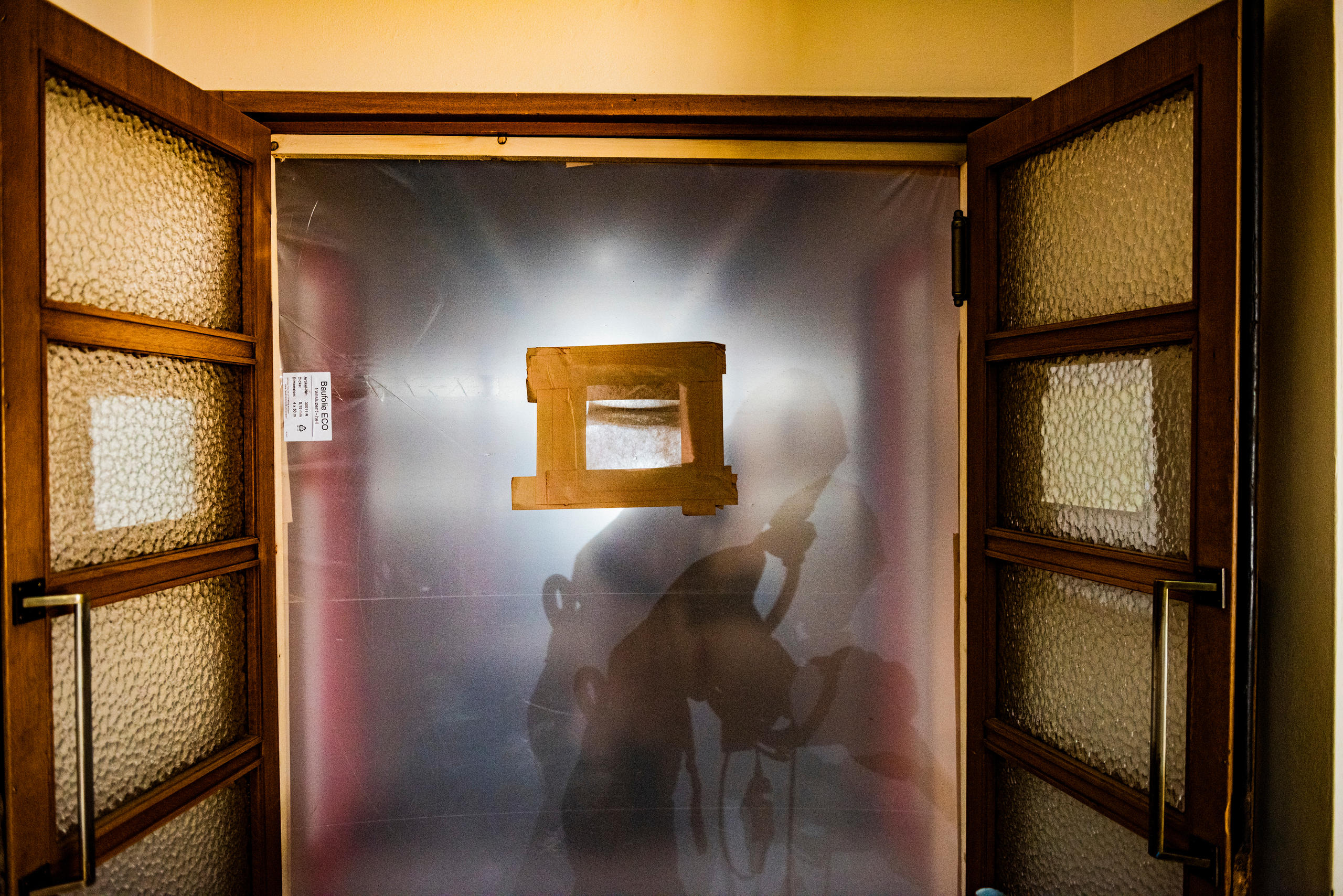 A worker wears breathing apparatus in a sealed off corridor.