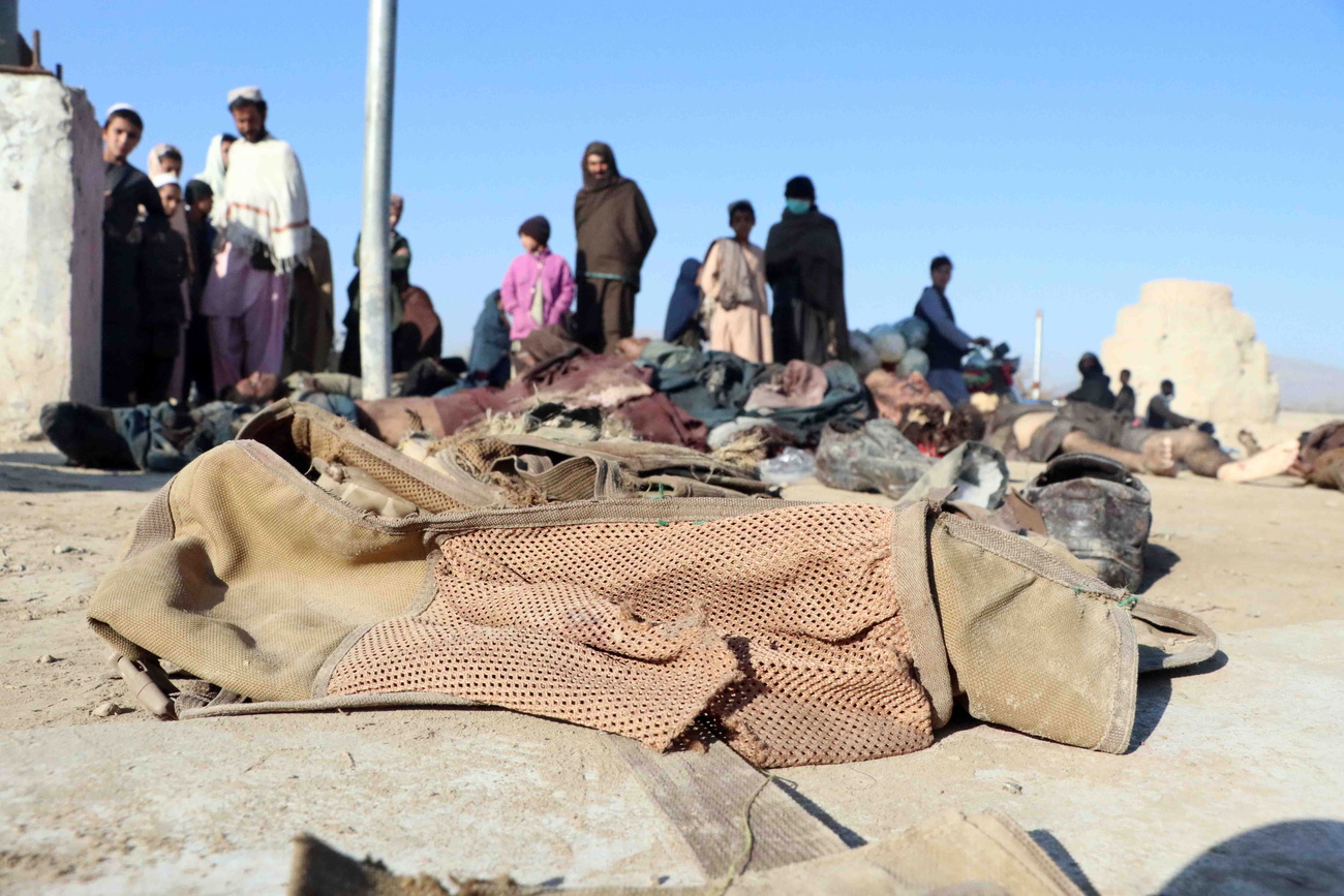 People gather beside bodies of suspected Taliban fighters killed in an airstrike