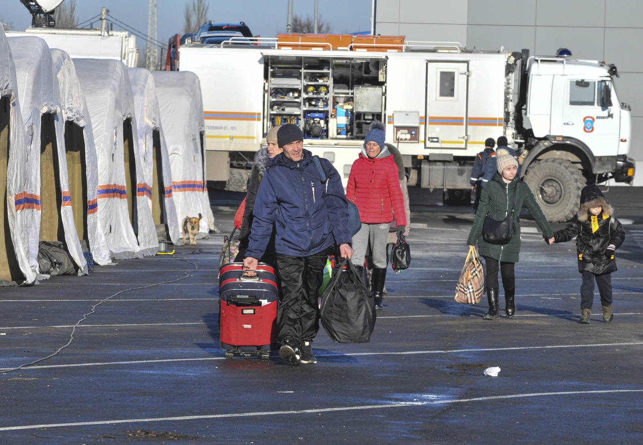 Persone in campo profughi con valigie