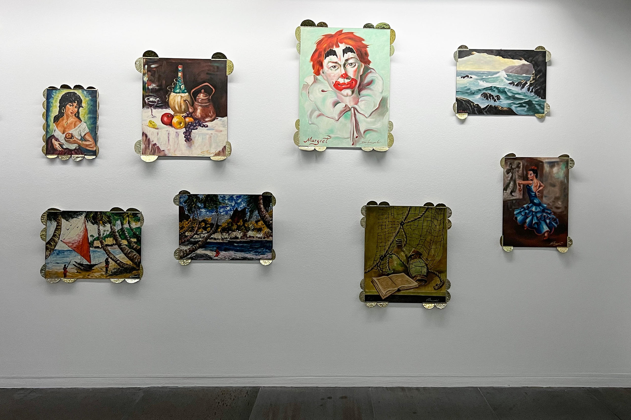 Huit tableaux accrochés à un mur.