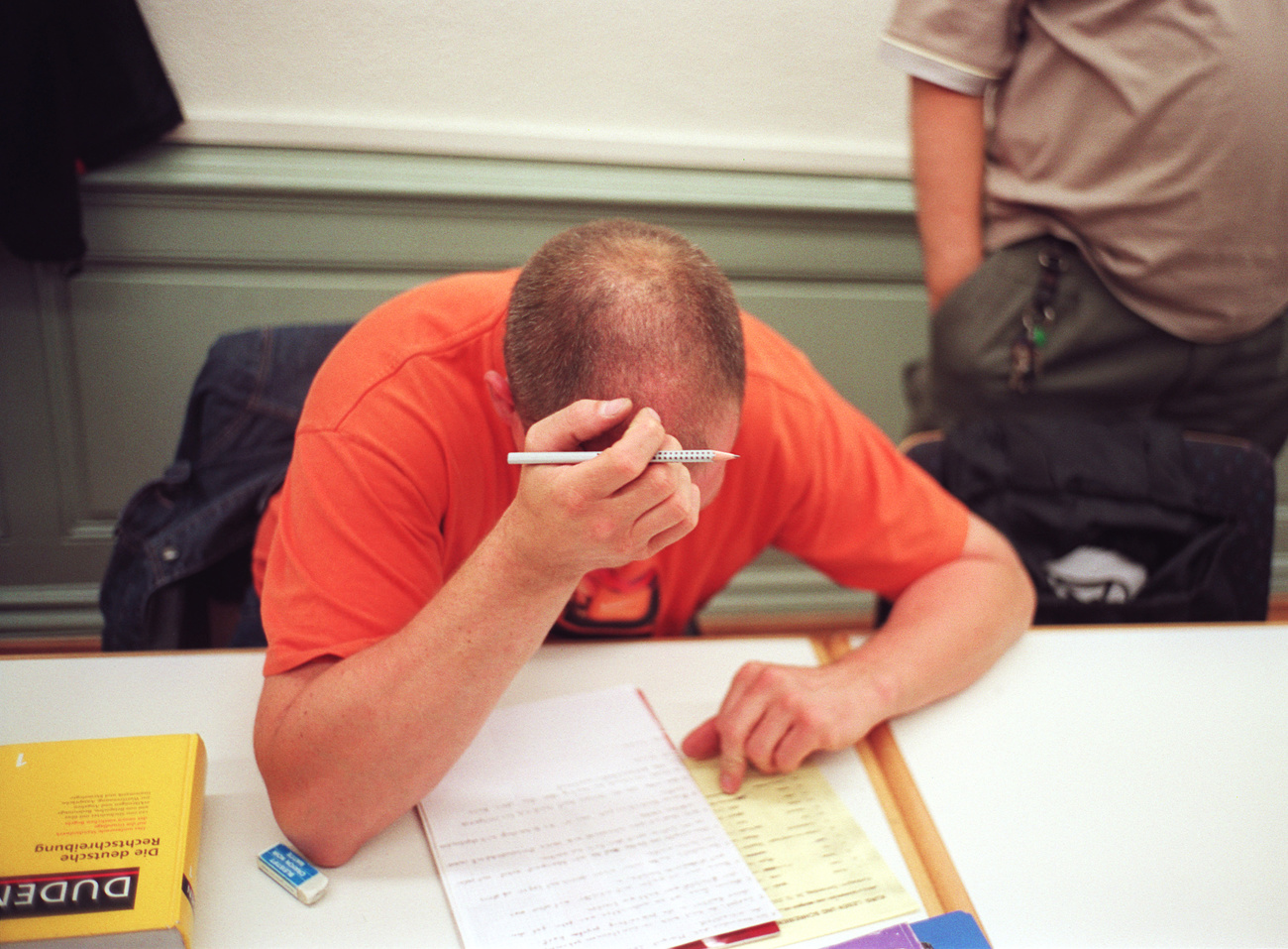 Un uomo in difficoltà mentre scrive una lettera.