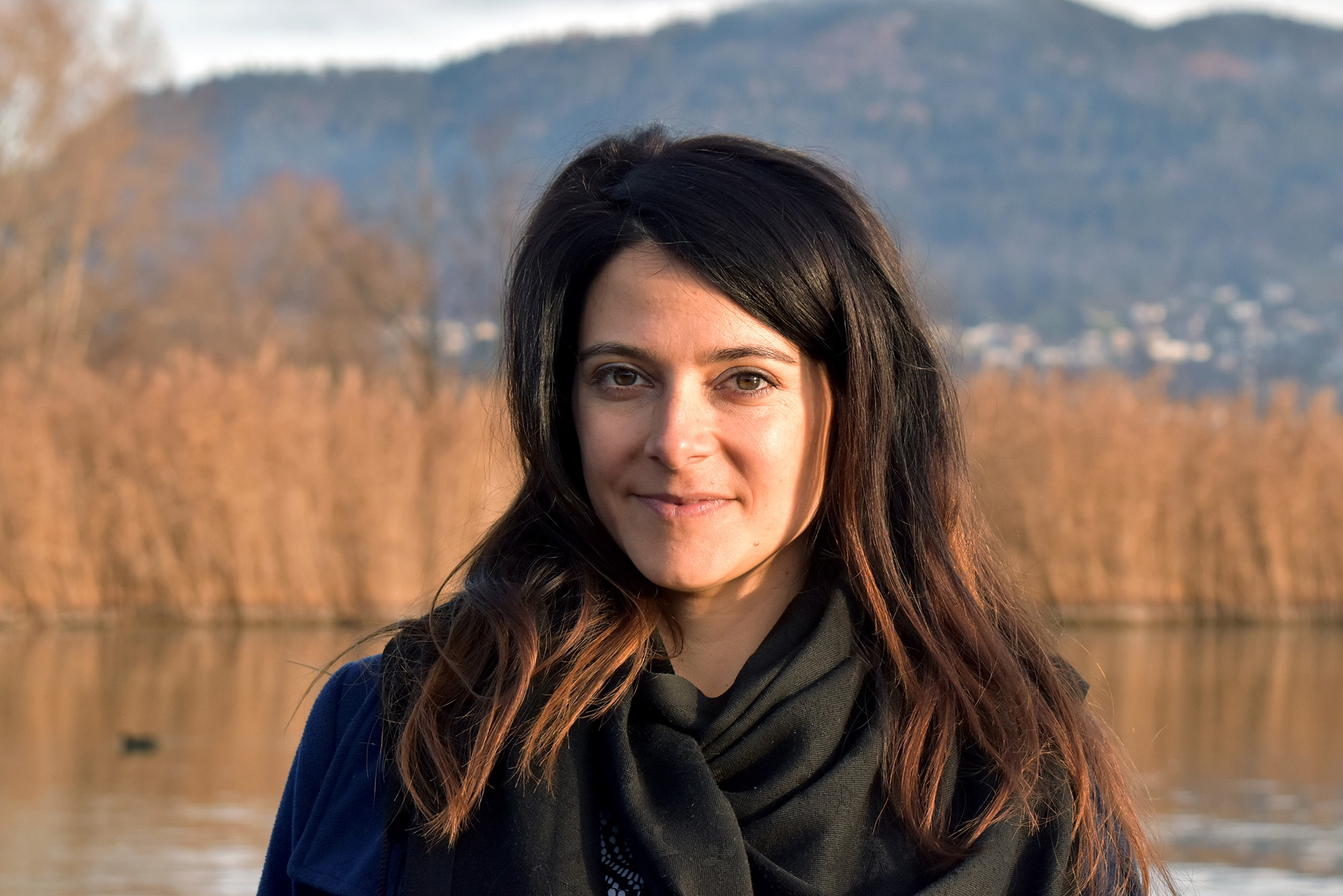 Femme brune posant au bord d un lac.