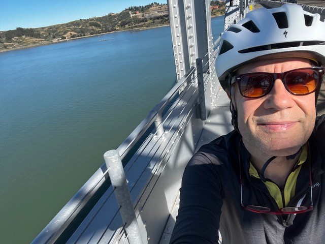 Homme à vélo sur un pont.