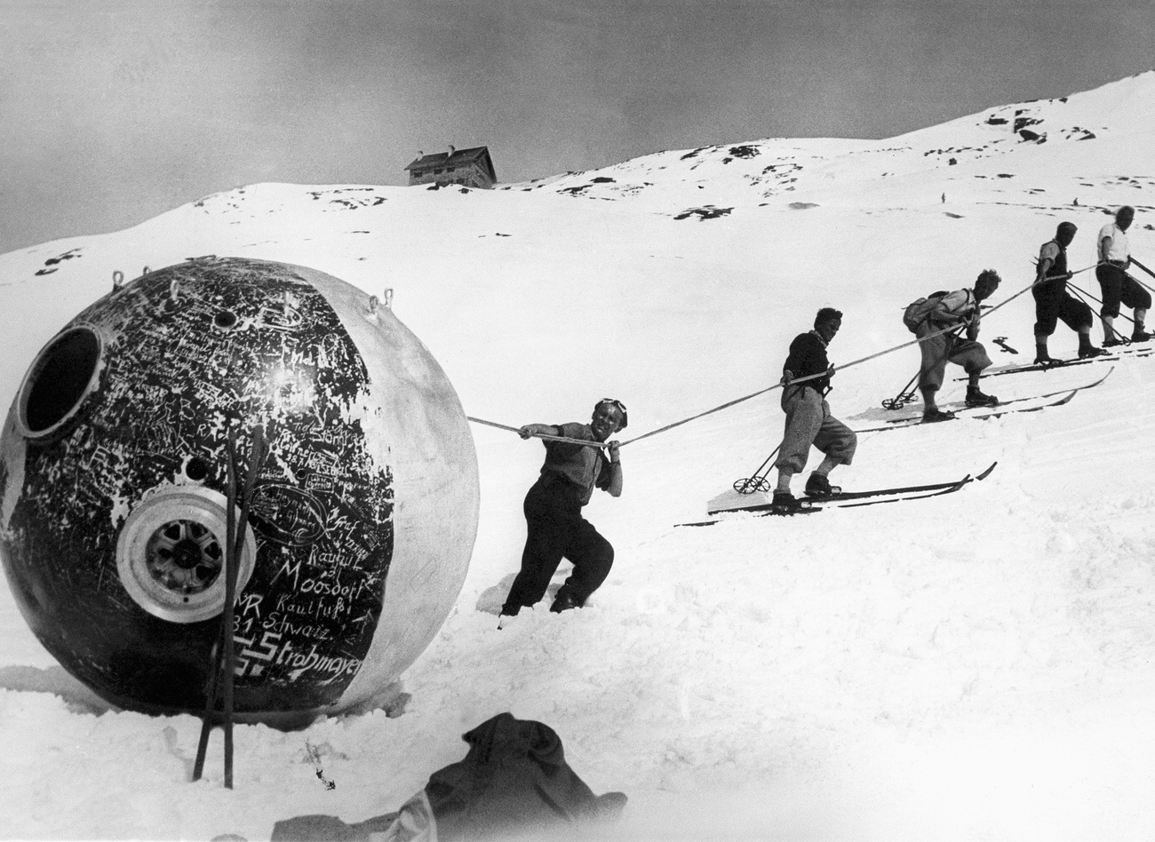 Menschen ziehen Ballon den Berg hinauf