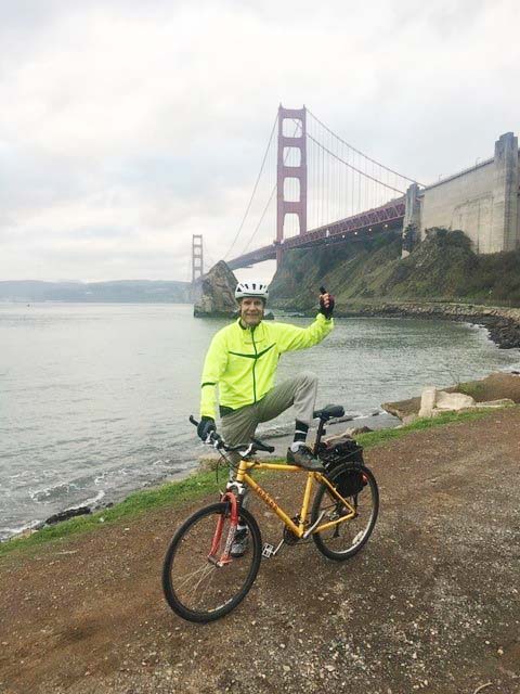 Homme à vélo devant le Golden Bridge de San Francisco