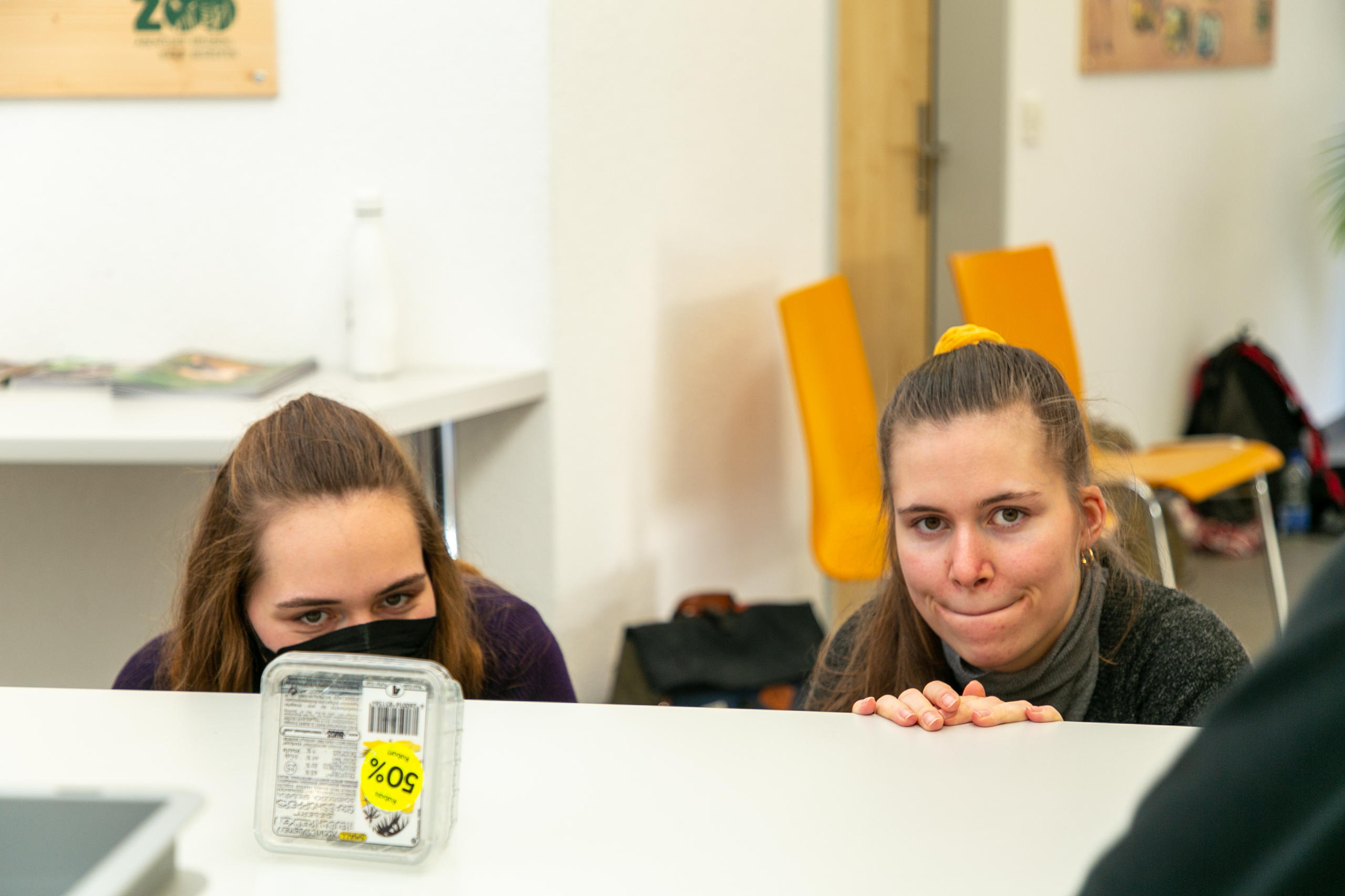 Des femmes regardent par dessus une table