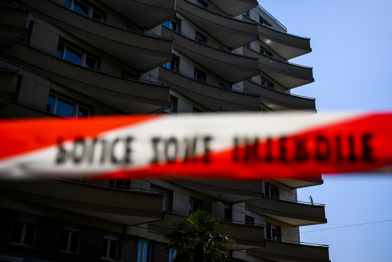 Dietro al nastro della polizia che sbarra l accesso, si vede il palazzo da dove si sono gettate le 5 persone.