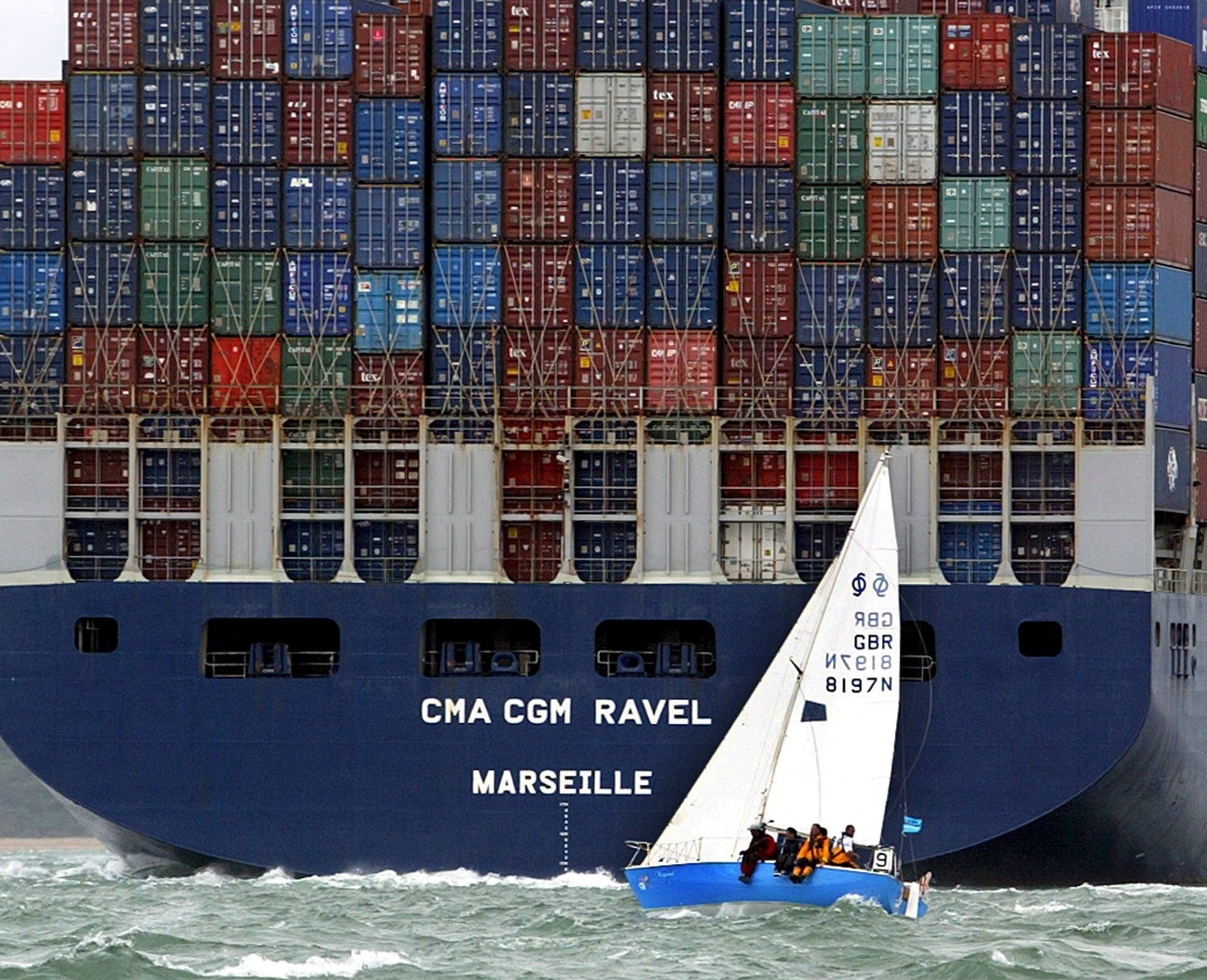 Ein Segelboot vor einem Container-Schiff