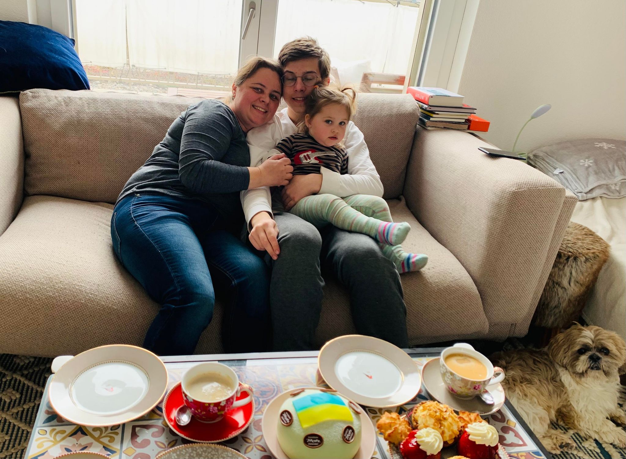 Une mère et ses deux enfants dans un canapé.