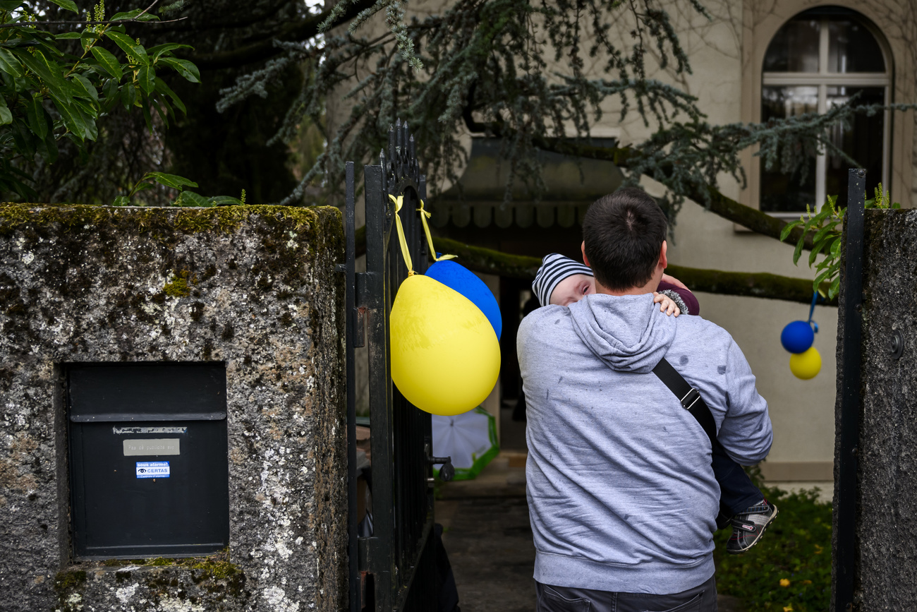 Papà e bebè accolti da palloncini gialli e azzurri.