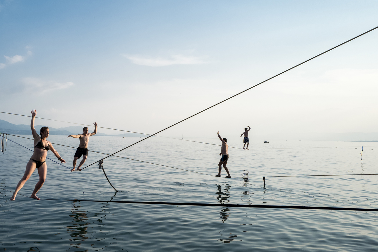 persone in equilibrio su corde tese sopra un lago