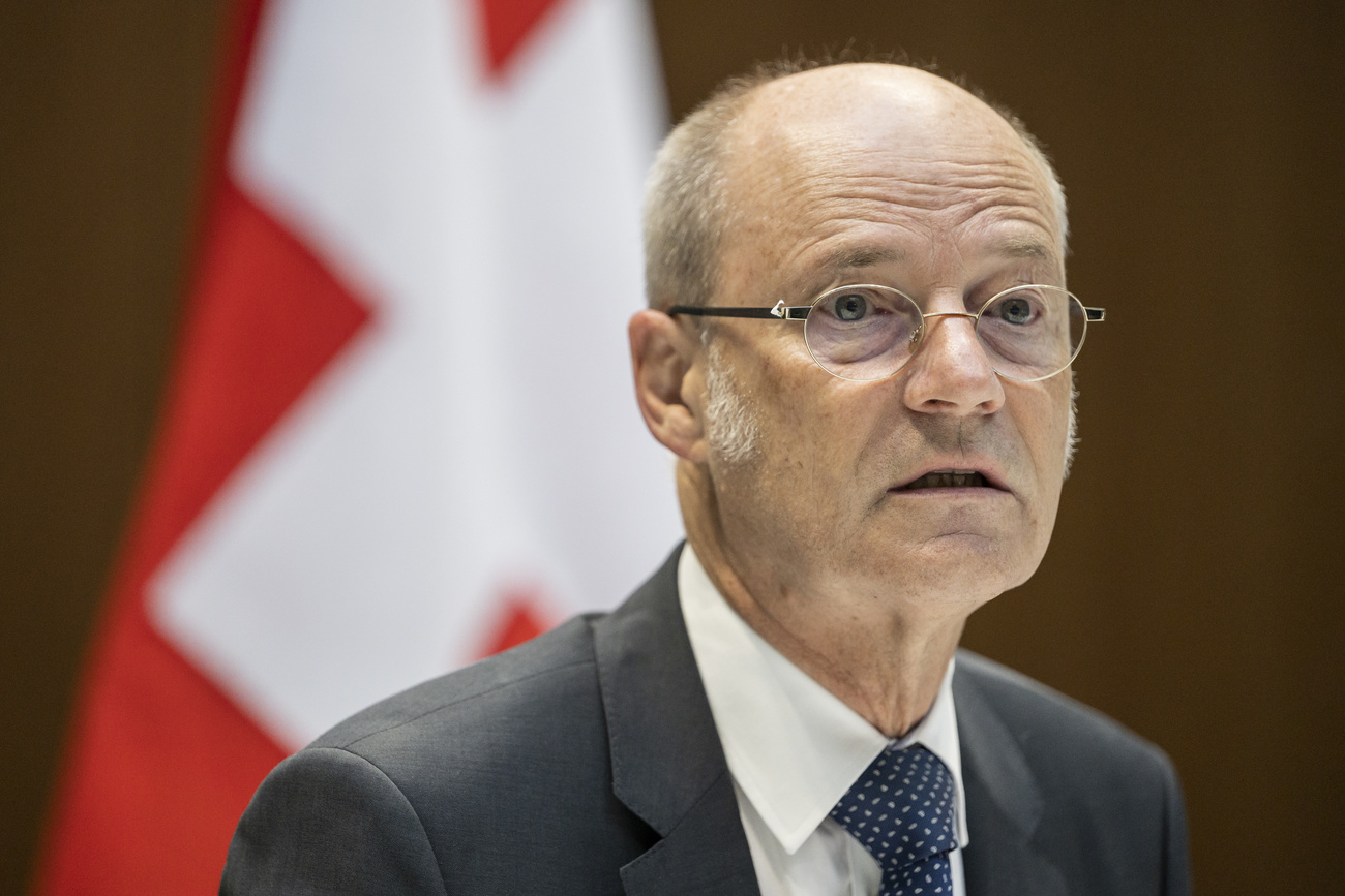 primo piano di uomo anziano con bandiera svizzera dietro di lui